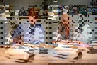 Male and female visitors to the reading room looking at book